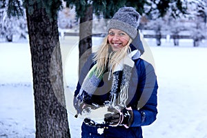 Beautiful winter portrait of young woman in the winter snowy scenery. Beautiful girl in winter clothes.