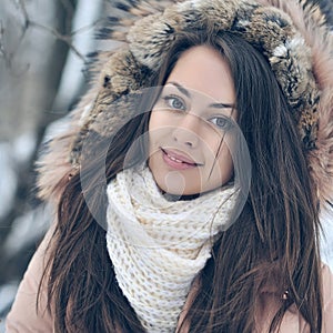 Beautiful winter portrait of young woman in the winter snowy scenery