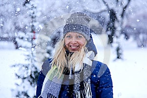 Beautiful winter portrait of young woman in the winter snowy scenery. Beautiful girl in winter clothes.