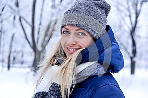 Beautiful winter portrait of young woman in the winter snowy scenery. Beautiful girl in winter clothes.