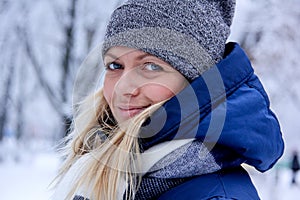 Beautiful winter portrait of young woman in the winter snowy scenery. Beautiful girl in winter clothes.