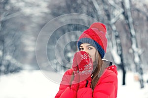 Beautiful winter portrait of young woman in the winter snowy scenery.