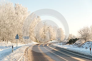 Beautiful winter road landscape. Cold weather, frost on trees. Asphalt road.