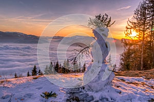 Beautiful winter sunset with snowman in foreground