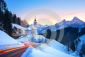 Beautiful winter wonderland mountain scenery in the Alps with pilgrimage church of Maria Gern and famous Watzmann summit in the