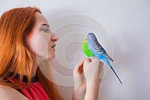 The beautiful woman admires her beautiful parrots