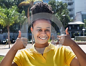 Beautiful woman with amazing hairstyle showing both thumbs up