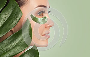 A beautiful woman applied hydrogel patches under her eyes. Anti aging skin care. Aesthetic cosmetology and makeup concept