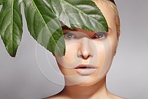 Beautiful woman applies Organic Cosmetic. Spa and Wellness. Model with Clean Skin. Healthcare. Picture with leaf