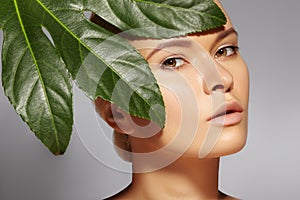 Beautiful woman applies Organic Cosmetic. Spa and Wellness. Model with Clean Skin. Healthcare. Picture with leaf