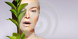 Beautiful woman applies Organic Cosmetic. Spa and Wellness. Model with Clean Skin, Natural Make-Up, leaf. Copy Space