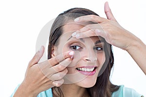 Beautiful woman applying contact lens