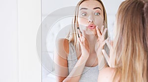 Beautiful woman applying hygienic lip balm near mirror, Attractive young woman applying lip balm and look at the mirror