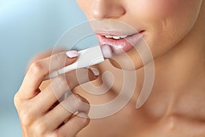 Beautiful Woman Applying Lip Protector On Lips Skin. Beauty