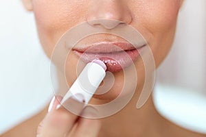 Beautiful Woman Applying Lip Protector On Lips Skin. Beauty