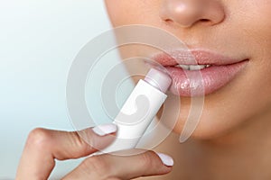 Beautiful Woman Applying Lip Protector On Lips Skin. Beauty