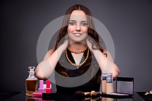 The beautiful woman applying make-up in fashion concept