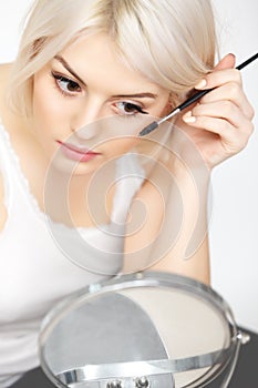 Beautiful Woman applying Mascara on Eyelashes. Eye Makeup