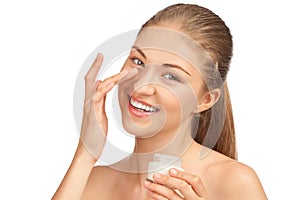 Beautiful woman applying moisturizer cream