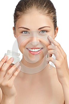Beautiful woman applying moisturizer cream