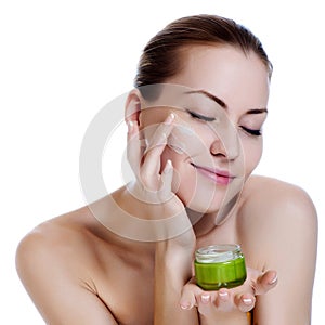 Beautiful woman applying moisturizer cream