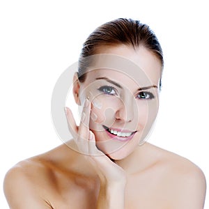 Beautiful woman applying moisturizer cream