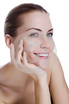 Beautiful woman applying moisturizer cream