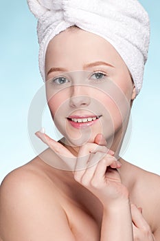 Beautiful woman applying moisturizer cream on face