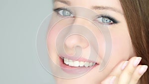 Beautiful woman applying organic cosmetic cream, touching her face with facial massage lines, perfect healthy skin and