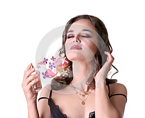 Beautiful woman applying perfume with floral scent on background