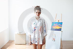 Beautiful woman artist standing in her art studio