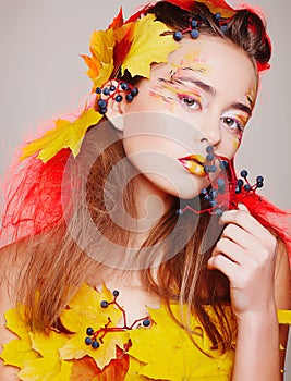 Beautiful woman with autumn make up posing in studio. Fashion co