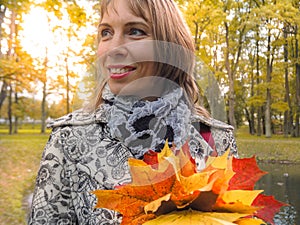 Beautiful woman in autumn Park. Woman in autumn Park with colorful maple leaves. Autumn mood.