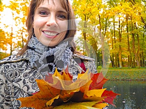 Beautiful woman in autumn Park. Woman in autumn Park with colorful maple leaves. Autumn mood.