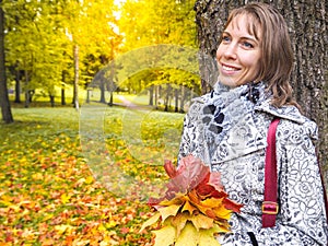 Beautiful woman in autumn Park. Woman in autumn Park with colorful maple leaves. Autumn mood.