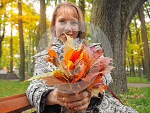 Beautiful woman in autumn Park. Woman in autumn Park with colorful maple leaves. Autumn mood.