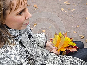 Beautiful woman in autumn Park. Woman in autumn Park with colorful maple leaves. Autumn mood.