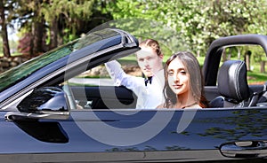 Beautiful woman in back prom dress and handsome guy in suit, teenager ready for a luxury night.