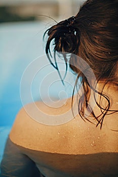 Beautiful woman back  with water drops close up, relaxing in pool. Back view of brunette girl with wet skin with goosebumps.