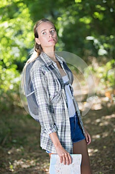 Beautiful woman with backpack lost in night forest