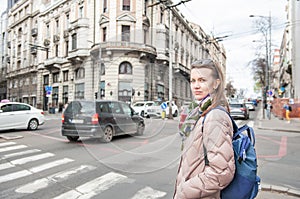 Beautiful woman with bagpack and sunglasses standing on the street in the Belgrade city, Serbia photo