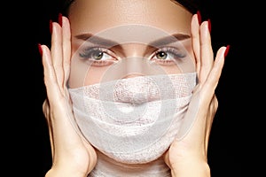 Beautiful woman with bandage face mask. Fashion eye make-up. Beauty surgery or protection hygiene in covid-19 pandemic