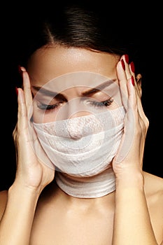 Beautiful woman with bandage mask on face. Fashion eye make-up. Beauty surgery or protection hygiene in virus pandemic