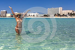 Beautiful woman bathing happily on blue seagull beach in Cancun in Riviera Mayan Mexico.