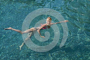 Beautiful woman bathing in a natural thermal pool