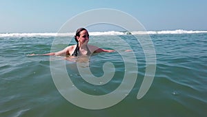 Beautiful woman bathing in the sea or ocean. Tourist woman swimming in ocean at summer resort on tropical. The girl is