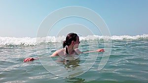 Beautiful woman bathing in the sea or ocean. Tourist woman swimming in ocean at summer resort on tropical. The girl is