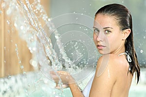 Beautiful woman bathing in spa looks at you