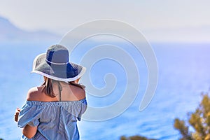 Beautiful woman in beach hat enjoying sea view with blue sky at sunny day in Bodrum, Turkey. Vacation Outdoors Seascape Summer