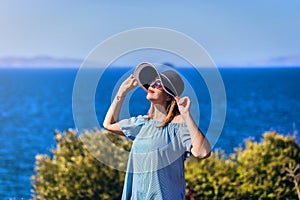 Beautiful woman in beach hat enjoying sea view with blue sky at sunny day in Bodrum, Turkey. Vacation Outdoors Seascape Summer